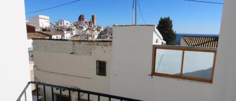 A white building with a balcony and a window.