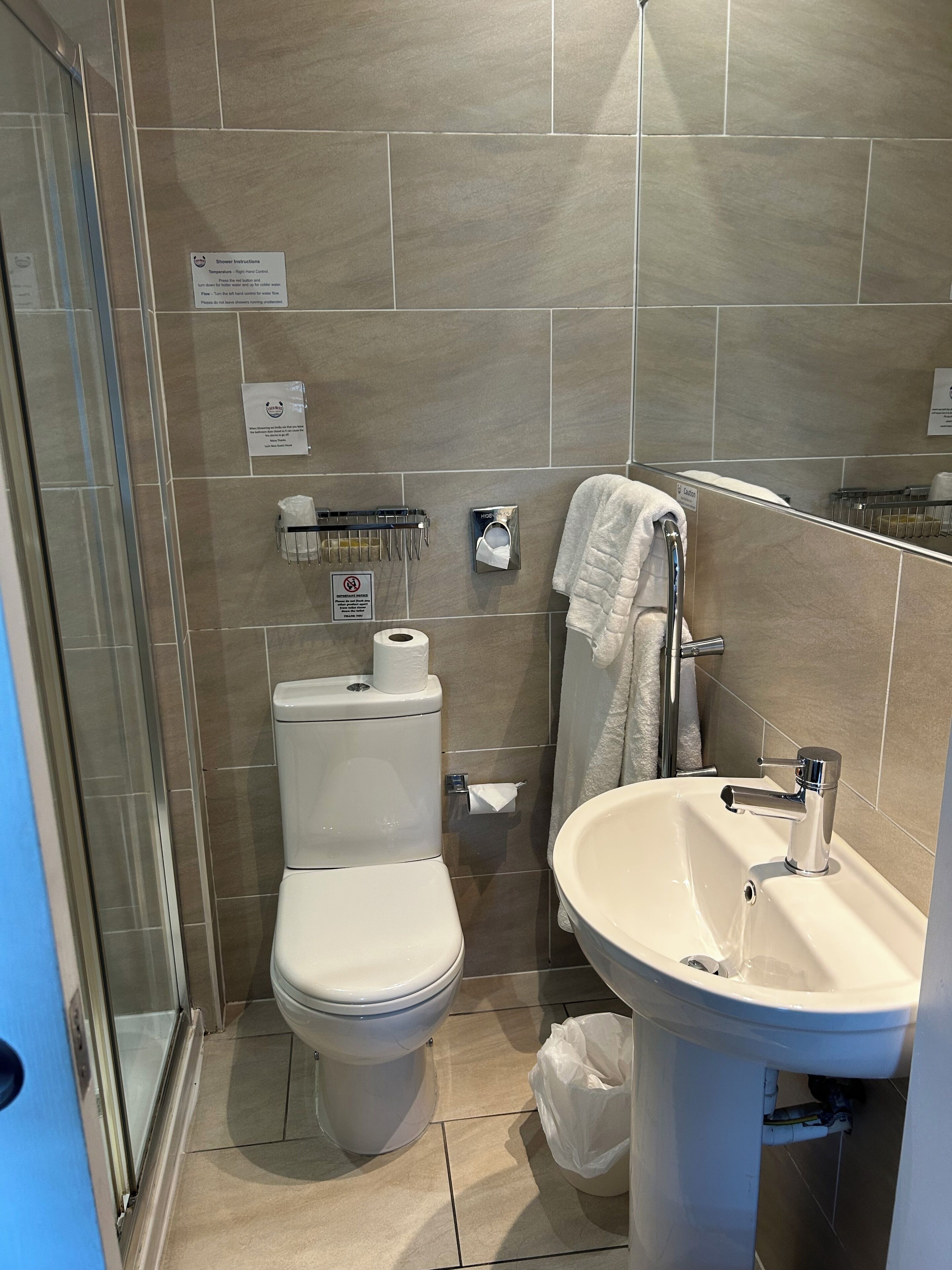 Un baño con inodoro, lavabo y zona de ducha.