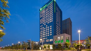A high-rise hotel with a modern design, featuring a prominent "Holiday Inn" sign, multiple floors, and a well-lit facade. - Holiday Inn Nanjing Harbour by IHG (Nanjing)