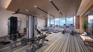 A modern gym with various exercise equipment, large windows, and a striped floor. - Holiday Inn Nanjing Harbour by IHG (Nanjing)