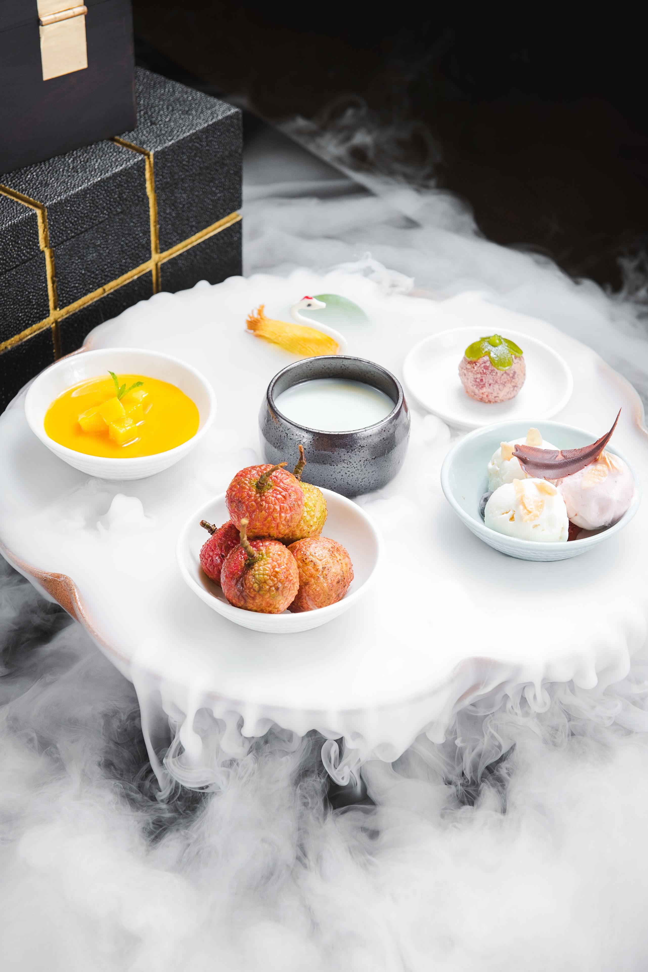 Une table sur laquelle sont disposés divers aliments, et une boîte noire en arrière-plan.