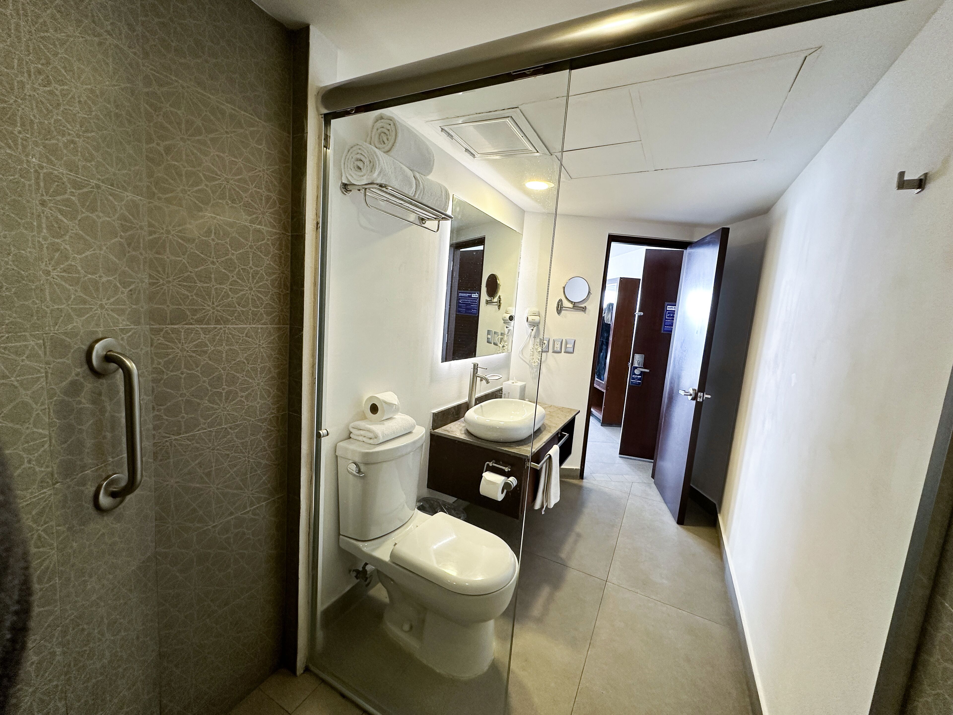 Un baño moderno con inodoro, lavamanos y secador de manos.
