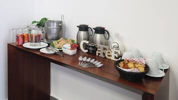 Un bufé de desayuno con diversas opciones de comida, bebidas y equipo para café.