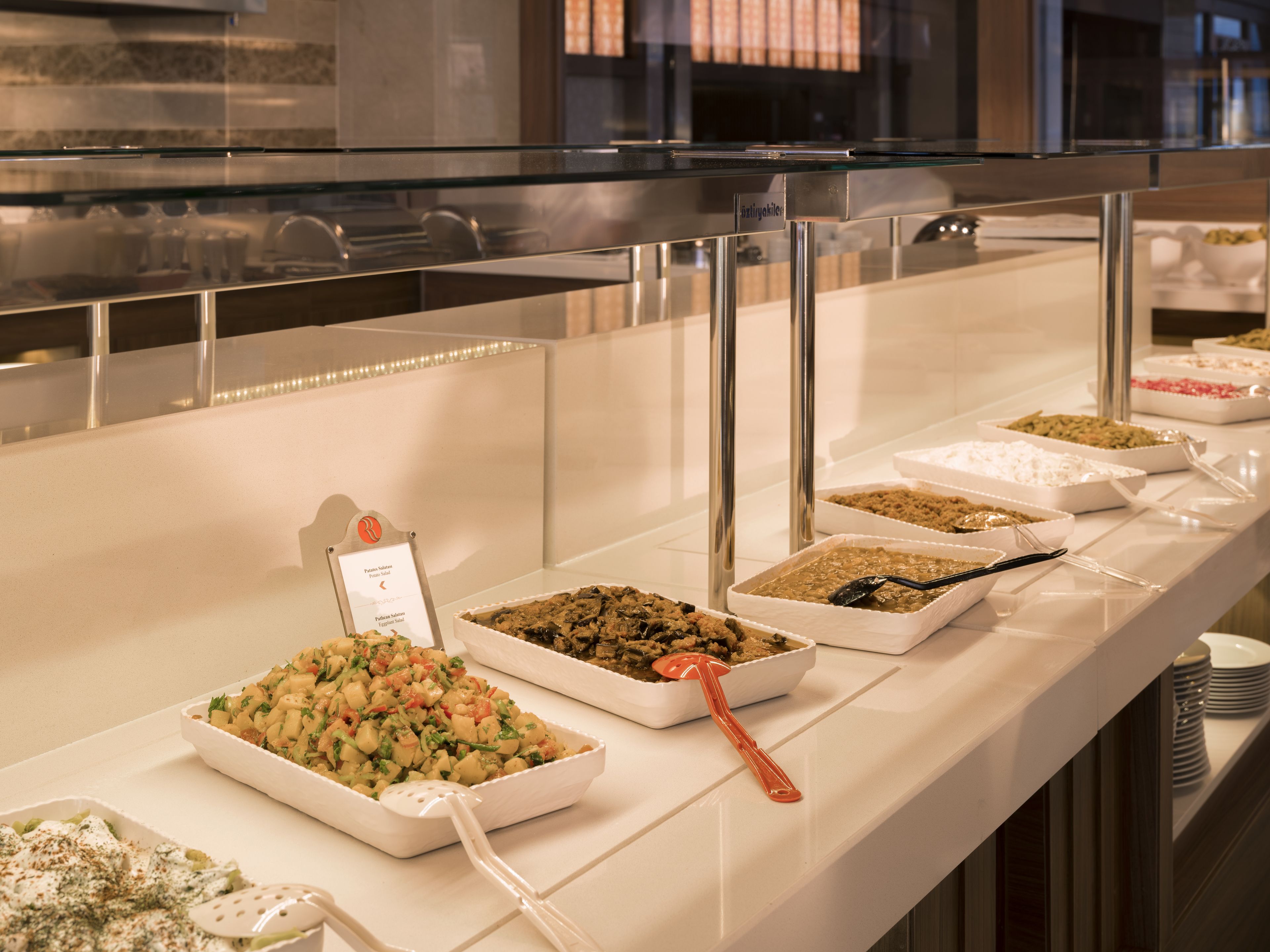 Un bufé con diferentes alimentos y utensilios para servir.