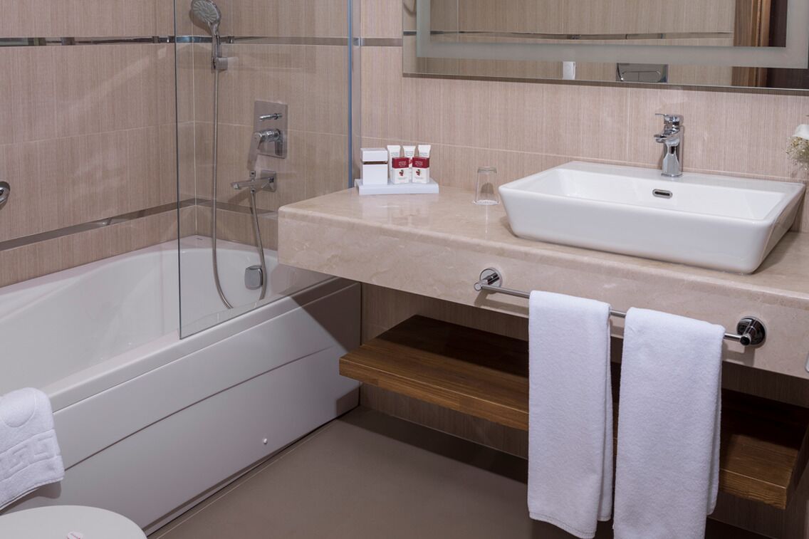 A modern bathroom with a bathtub, a sink, and a mirror.