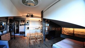 Un espace de vie compact comprenant un coin repas, une kitchenette et un espace nuit confortable.