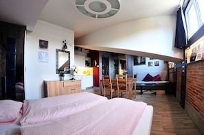 A compact hotel room with a bed, a small desk, a chair, and a dining table. - Alder Apartments (Kraków)
