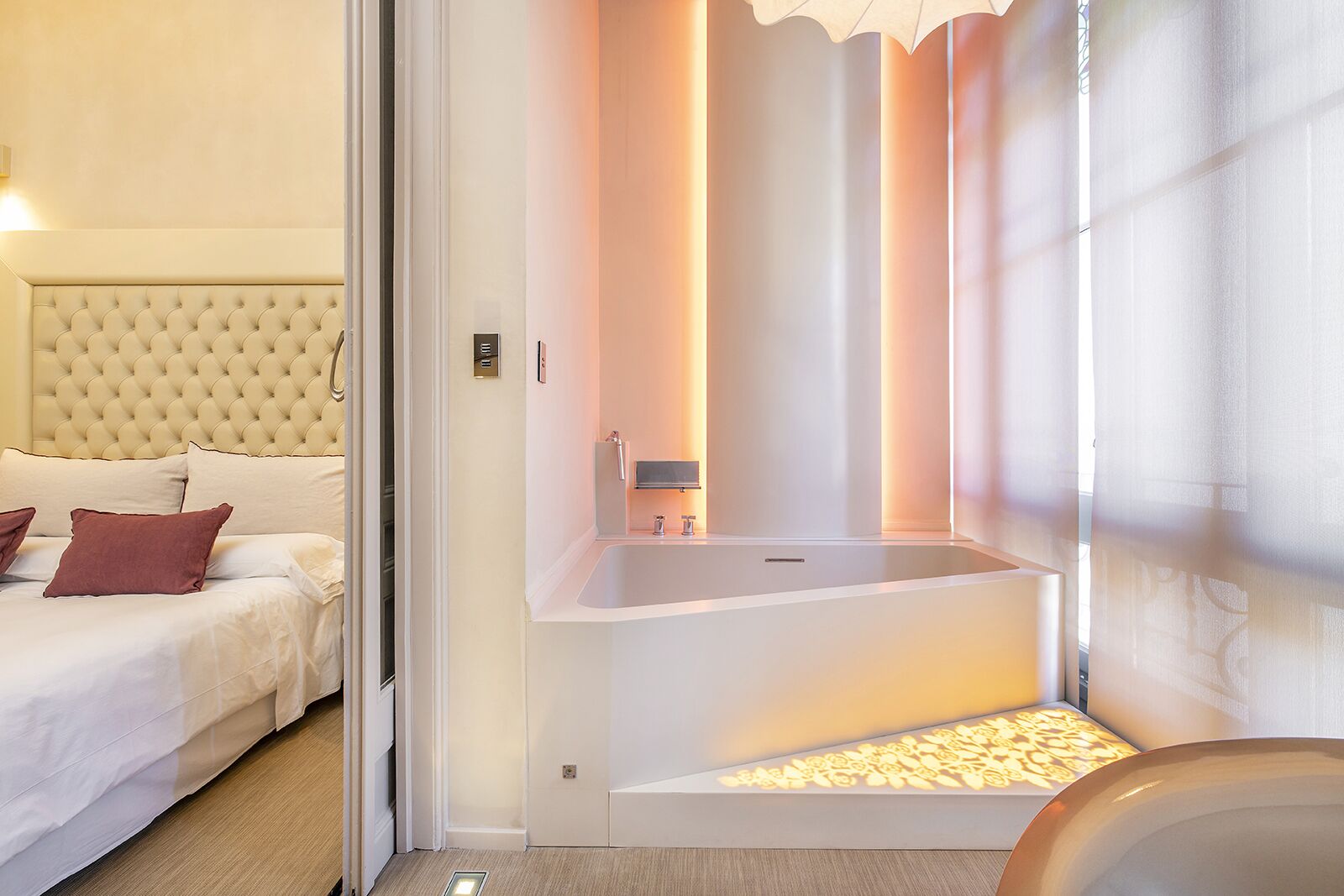 A modern hotel room with a large bed, a separate bathroom with a bathtub, and a shower.