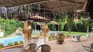 An outdoor patio with a pool, seating, and a pergola structure. - Hospedium Hacienda Las Cavas (Olmedo)