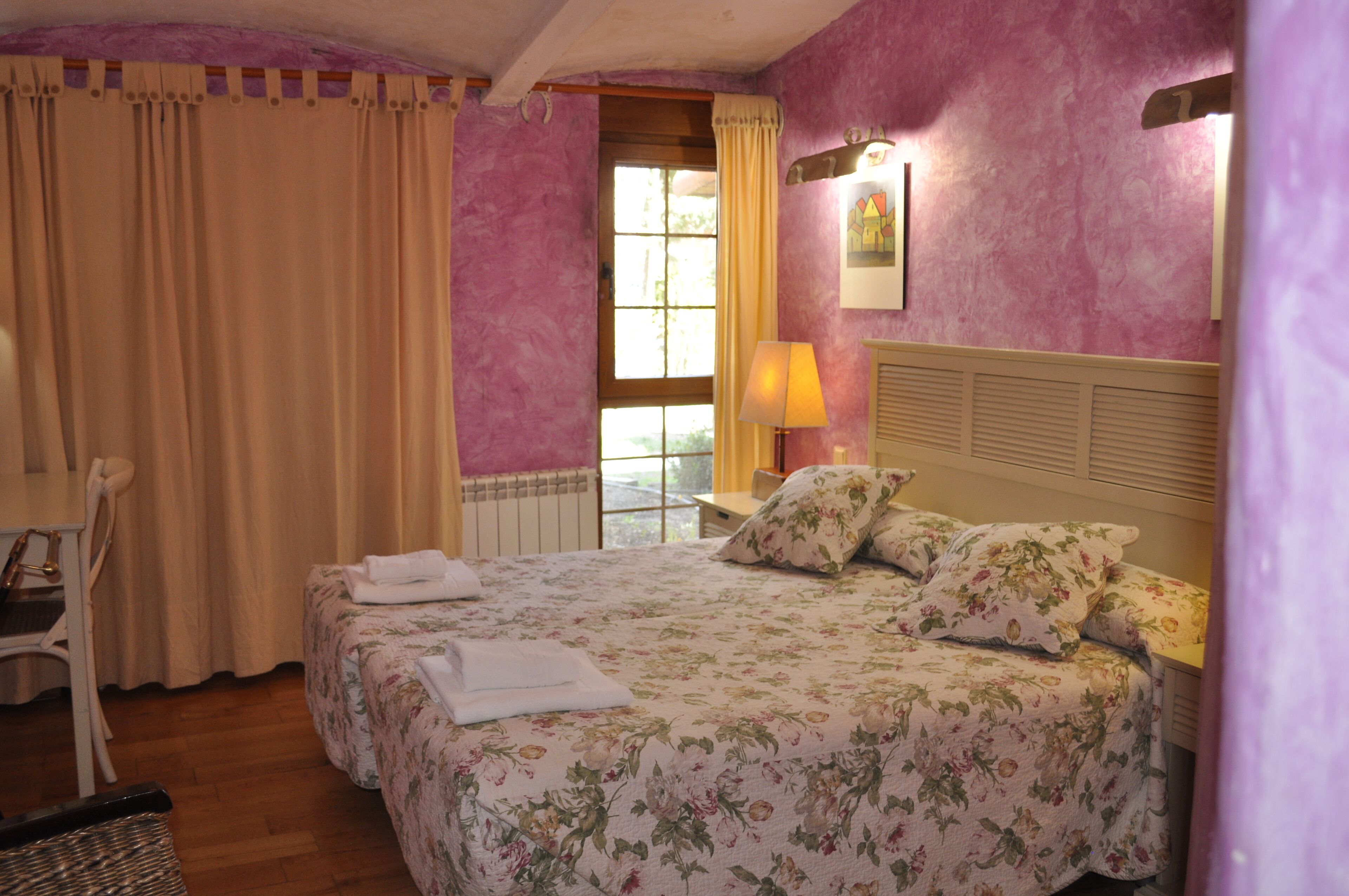 Une chambre avec deux lits, une chaise, une lampe et une fenêtre avec des rideaux.