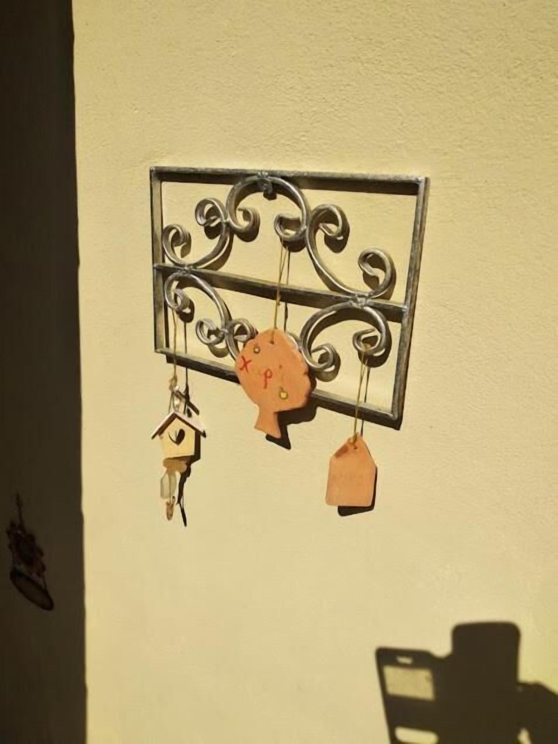 Uma estante de metal fixada na parede com três etiquetas penduradas.