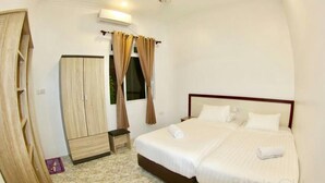 A bedroom with a bed, a wardrobe, and a window with curtains. - Bitos GH (Himmafushi)