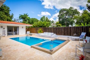 Alberca al aire libre y camastros 