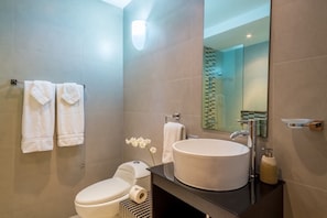 Ein modernes Badezimmer mit Toilette, Waschbecken und Spiegel.