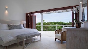 Un dormitorio con cama, banco y vistas al exterior.