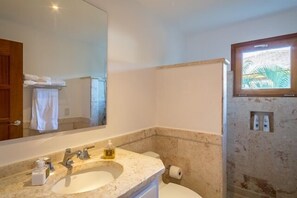 A bathroom with a sink, mirror, and toilet. - Designer Heaven (La Romana)