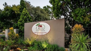 Een bordje voor 'Three Olives Guest House' met een website en telefoonnummer.