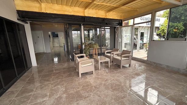 A spacious lobby with a tiled floor, wicker furniture, and a ceiling with exposed beams. - Ugurkan Otel (Kas)