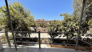 A view from a balcony with a metal railing, a tiled floor, and a clear blue sky. - Ugurkan Otel (Kas)
