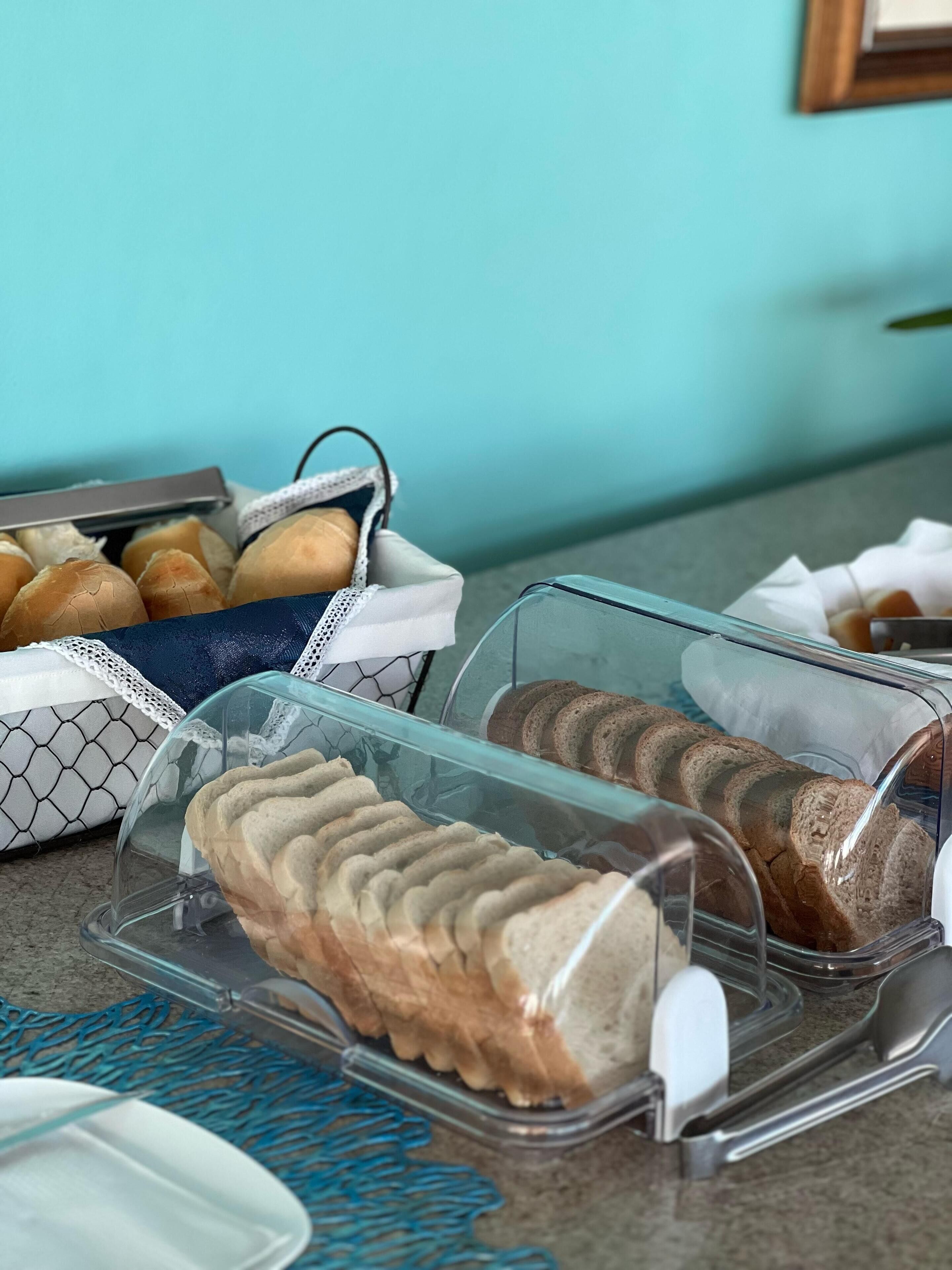 A buffet with various bread and pastries displayed in clear containers.