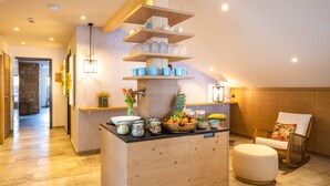 Una cocina con armarios de madera, un frutero y una estación para café.