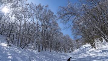 A snowy landscape with a snowboarder.