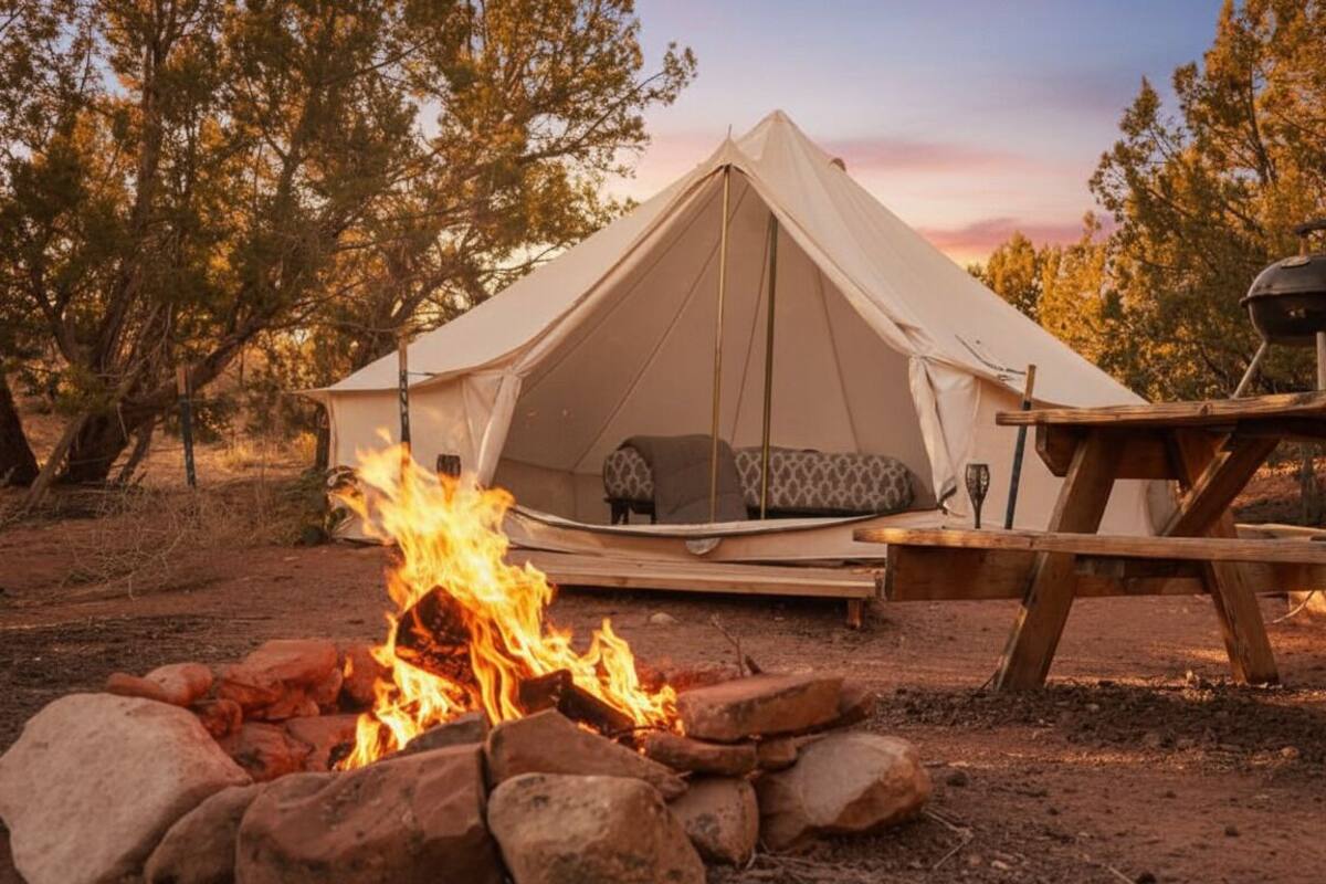 A tent with a sleeping area and a fire pit in front.