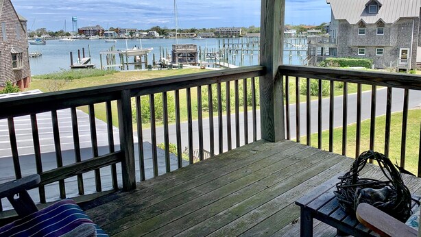 A wooden deck with a view of a marina and buildings. - Two If By Sea I and II: Larger home with fabulous views of Silver Lake (Ocracoke)