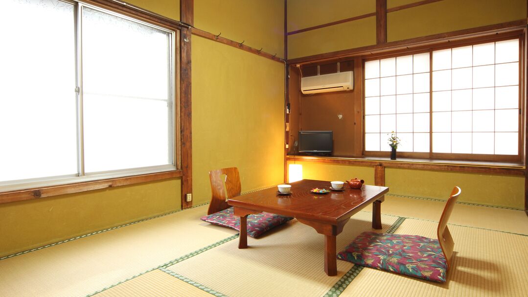 Habitació japonesa tradicional amb sòcols de tatami, una taula de fusta baixa i una porta corredissa.