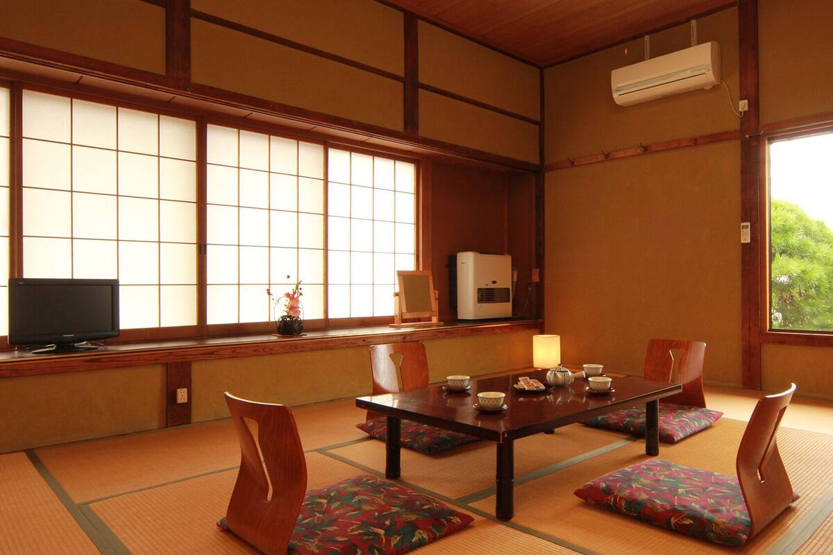 A traditional Japanese room with tatami flooring, a low table, and shoji screens.