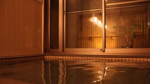 Un sol carrelé à la surface réfléchissante, une clôture en bois et une fenêtre équipée de luminaires.
