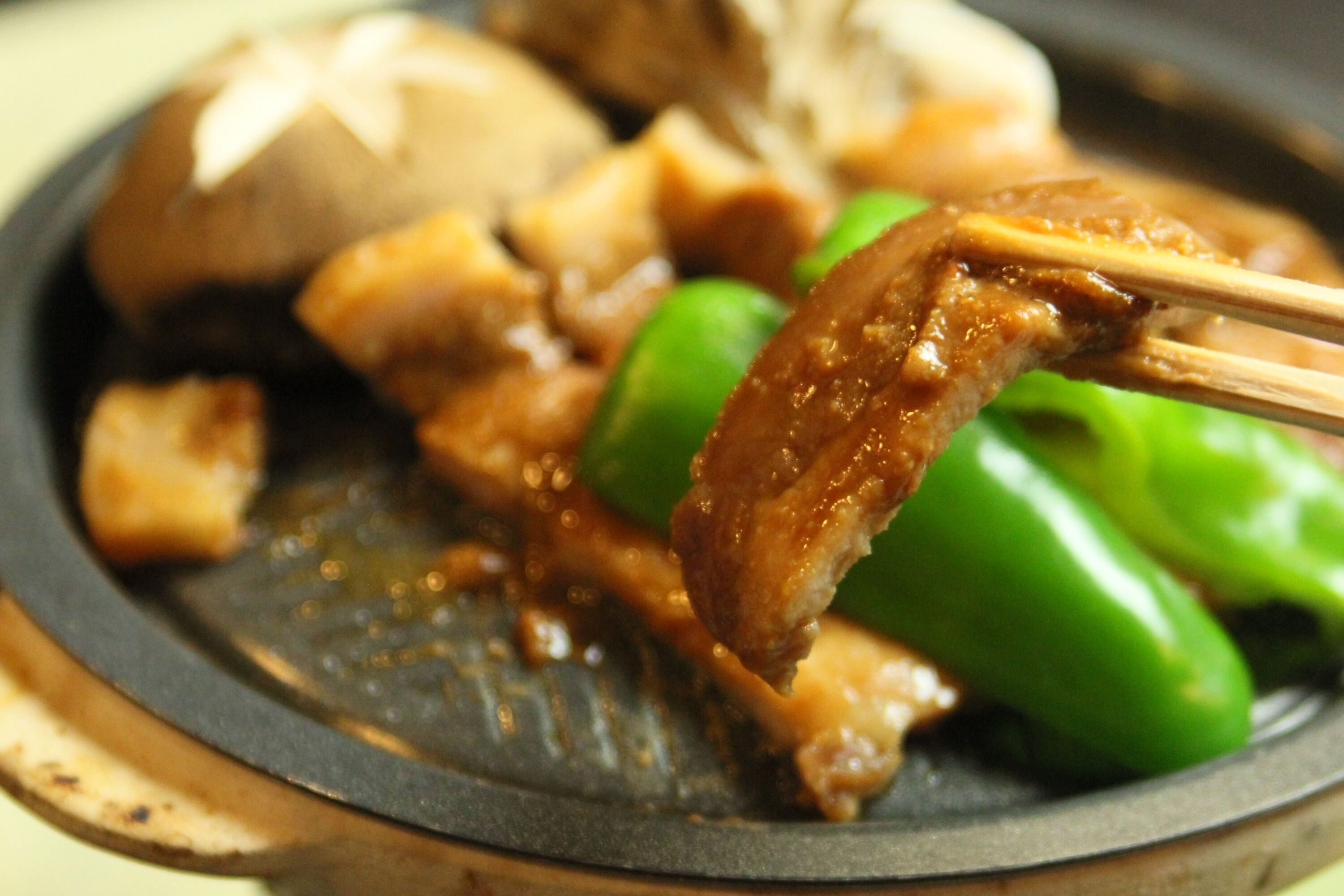 Primer plano de un plato con carne y verduras verdes.