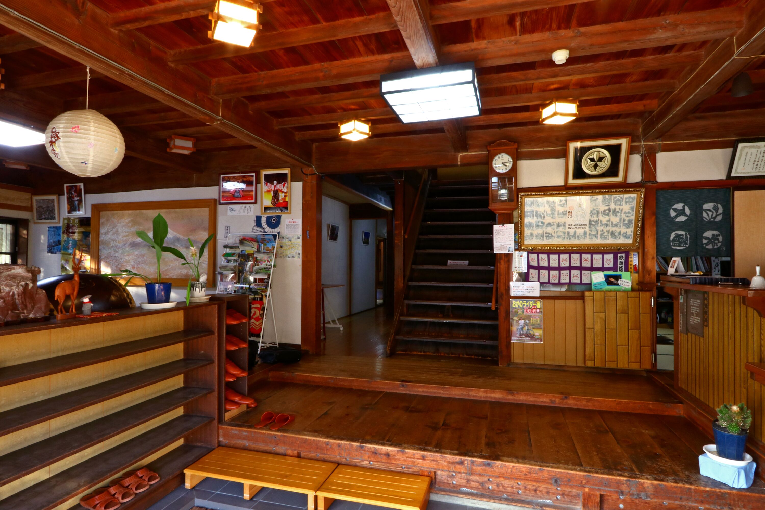Un interior de madera con una escalera, estanterías de madera y un mostrador de recepción.