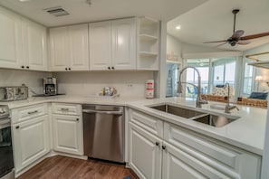 A modern kitchen with white cabinets, stainless steel appliances, and a dishwasher.