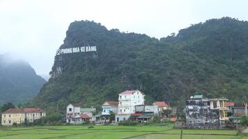 Un pueblo rural con casas y una gran montaña al fondo.