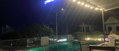 Una piscina al aire libre, sombrillas, sillones reclinables de piscina