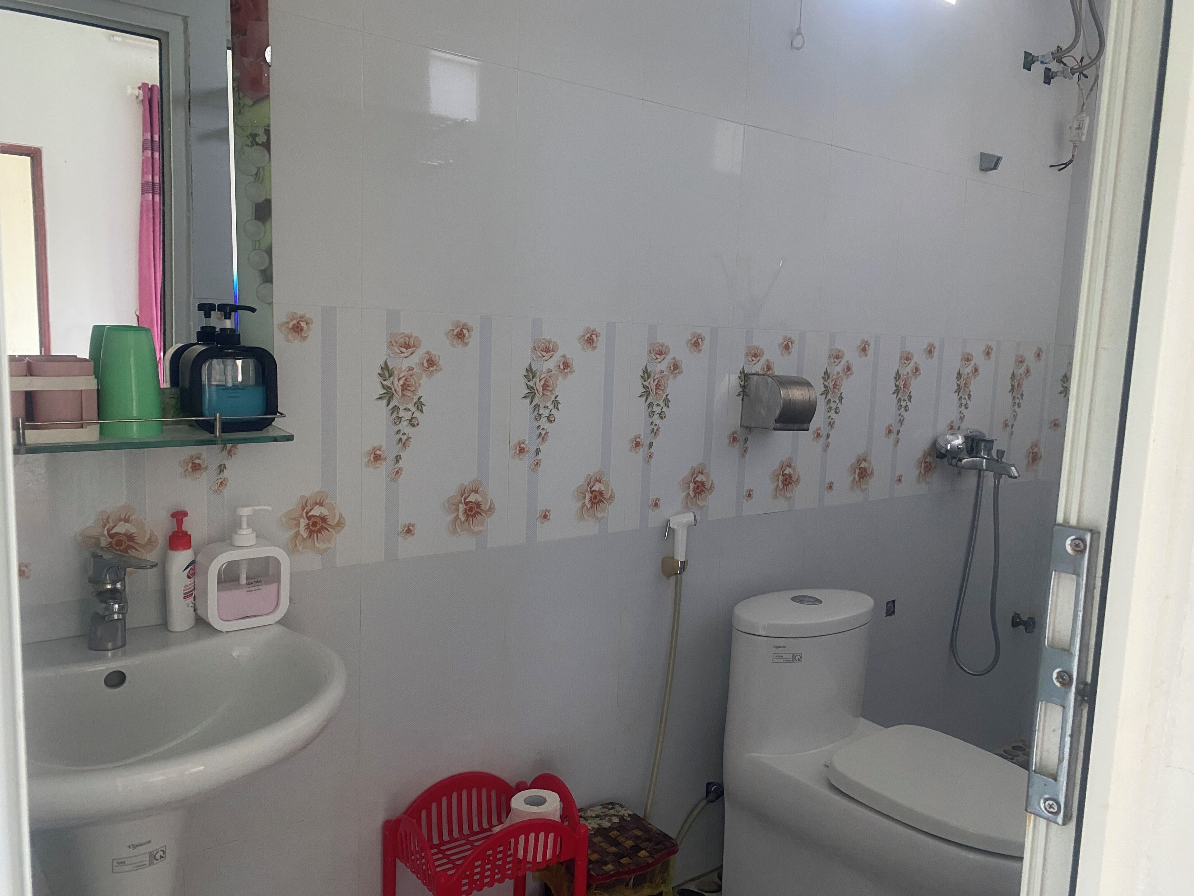 Un baño con lavamanos, inodoro, ducha y espejo.