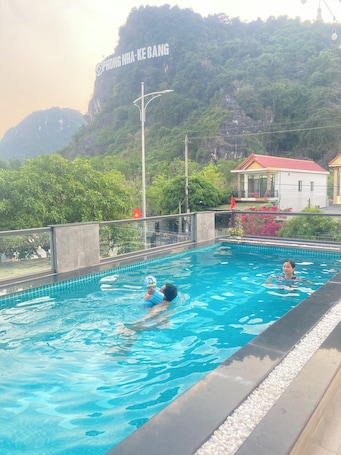Una piscina al aire libre, sombrillas, sillones reclinables de piscina