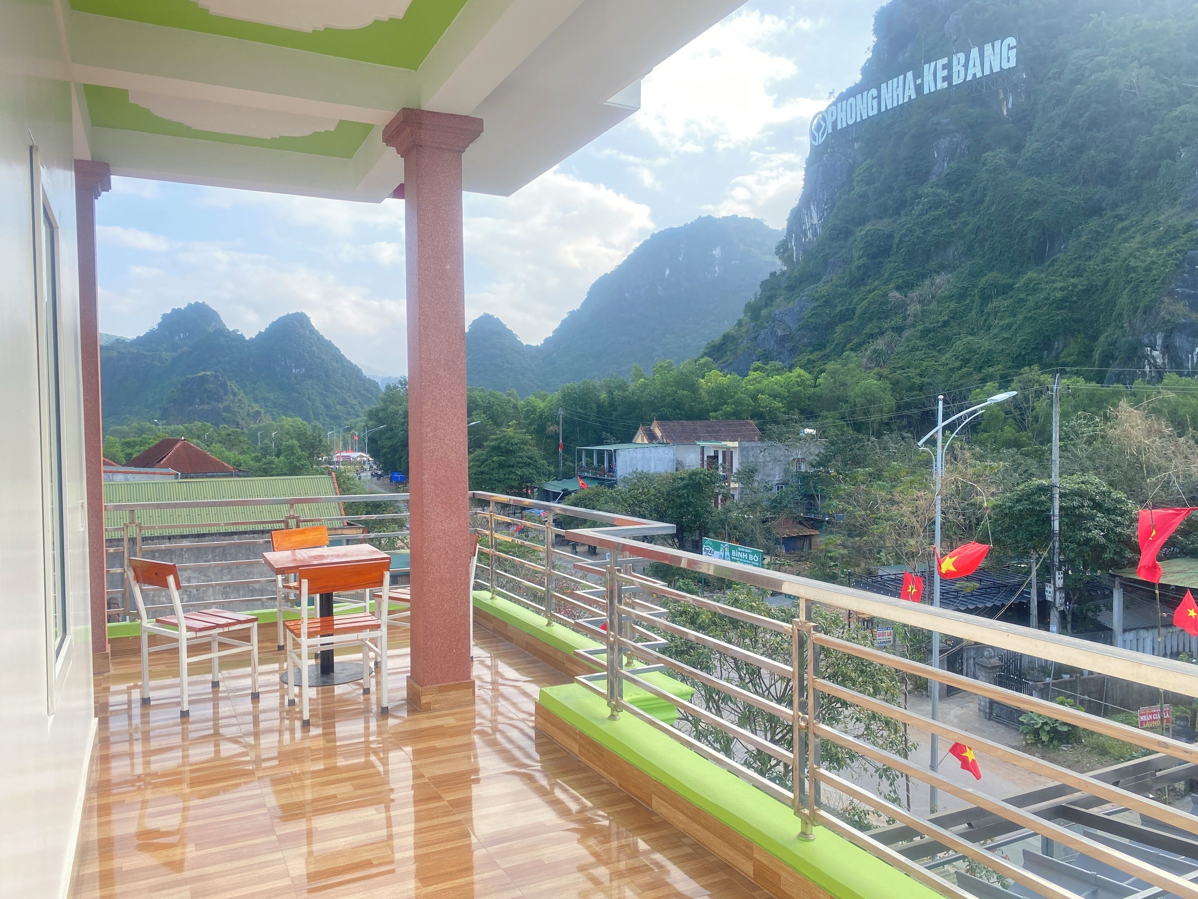 A balcony with a view of mountains and a sign reading "PHONG NHA-KE BANG".