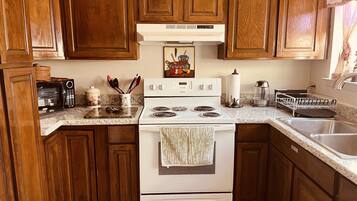 Prepare meals in a classic kitchen with a white stove and wooden cabinetry.