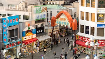 Een drukke stadsstraat met diverse winkels en een opvallende boog.