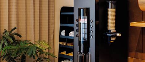 A modern kitchen with a built-in espresso machine, a coffee grinder, and a shelf with kitchenware.