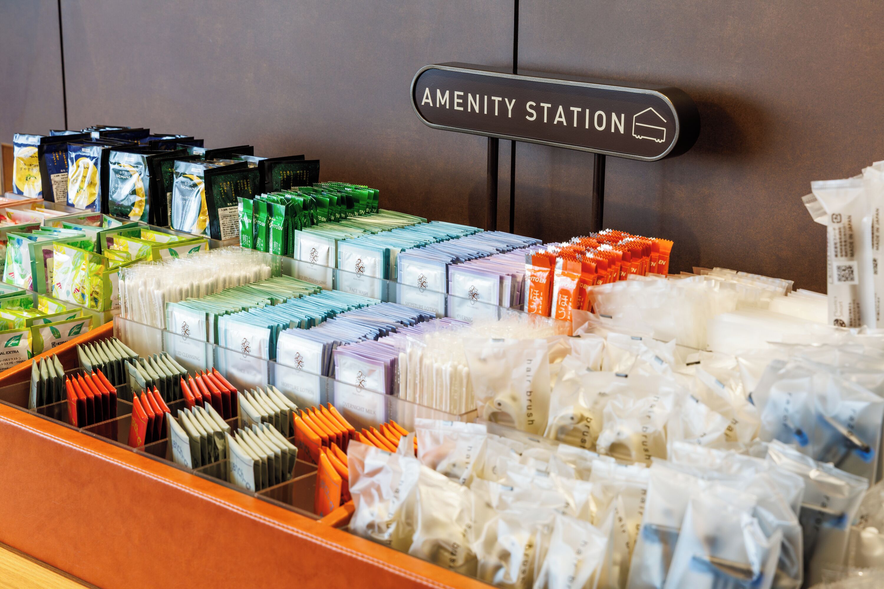 A display of toiletries in a hotel setting with a sign indicating the 'Amenity Station.'