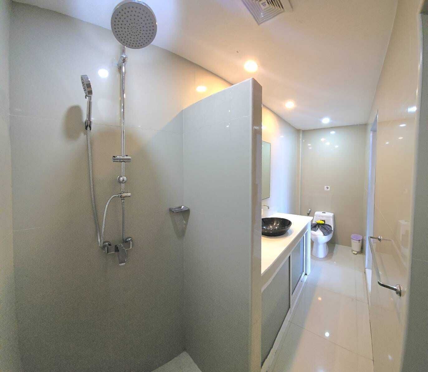 Une salle de bain moderne équipée d’une douche, de toilettes et d’un lavabo.