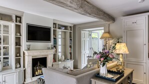 A living room with a fireplace, a television, and a sofa. - Rectory Cottage -  a beautiful cottage sleeping two guests (near Stamford)