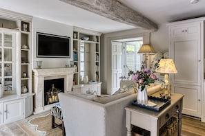 Un salon avec une cheminée, un téléviseur et un canapé.