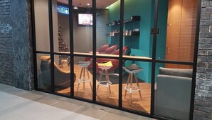 Un interior moderno con una zona de estar que incluye un sofá, dos sillones, una mesita y un árbol de Navidad.