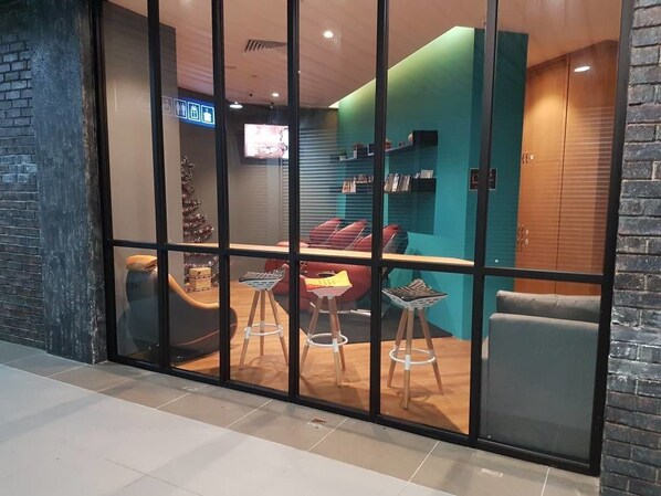 Un interior moderno con una zona de estar que incluye un sofá, dos sillones, una mesita y un árbol de Navidad.