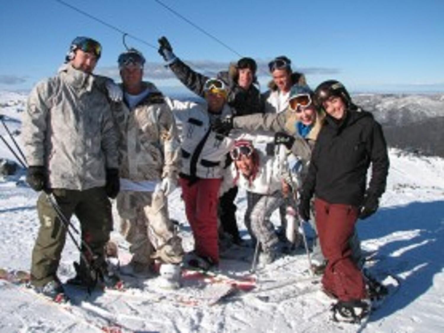 A group of people on a snowy mountain with ski equipment.