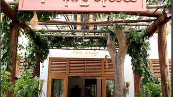 A wooden sign with the name 'Villa Bagan' and a tree carving, indicating a property name.